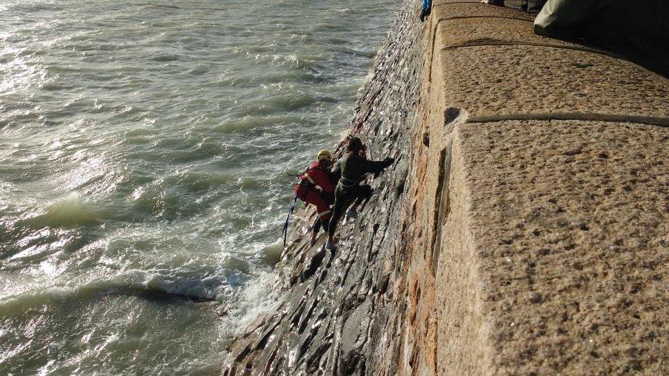 Firefighters rescuing teenagers cut off by the tide