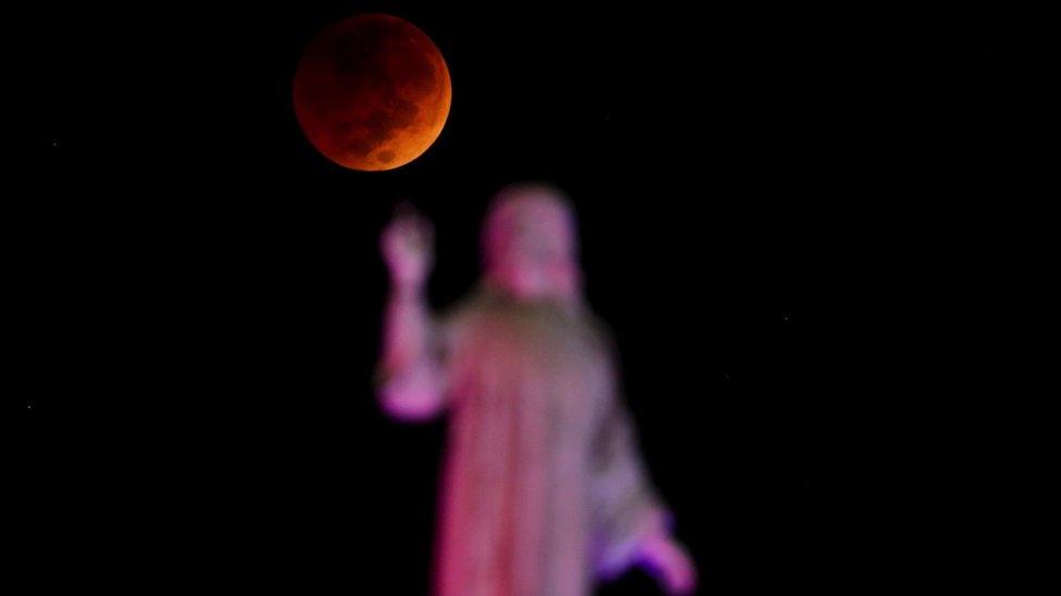 Moon against statue