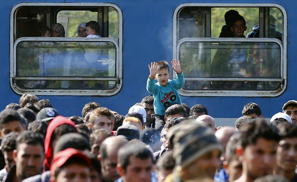 Migrants walk from train at Hegyeshalom, Hungary, to border with Austria