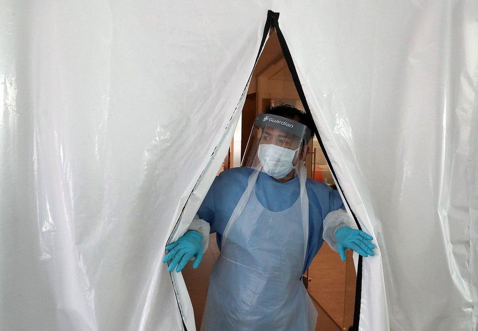 Technician in PPE at entrance to new laboratory