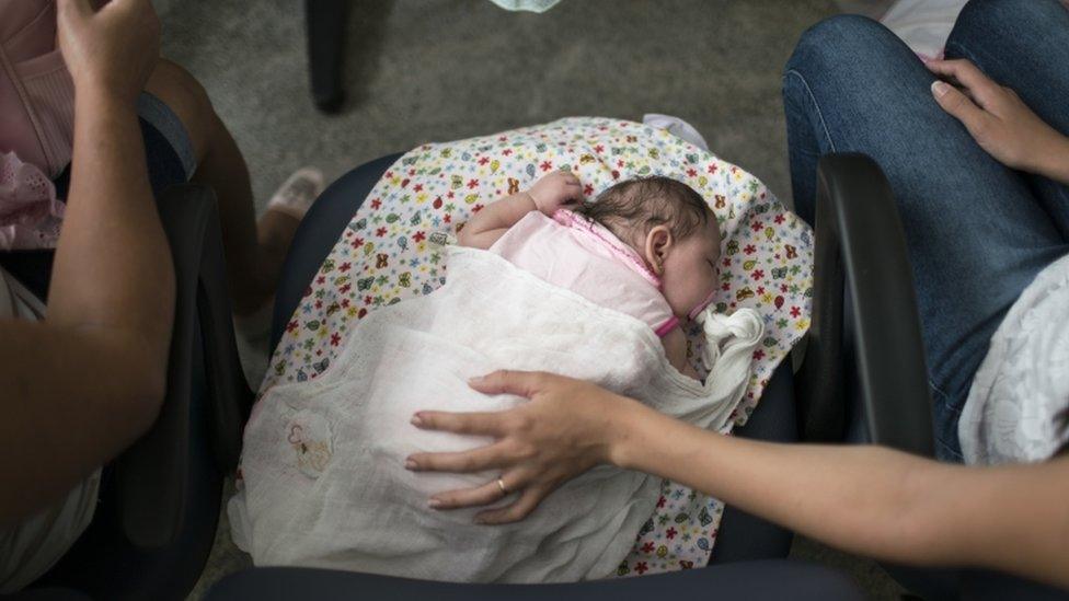 Angelica Pereira, right, holds her daughter Luiza, as she waits for their appointment with a neurologist at the Mestre Vitalino Hospital in Caruaru, Pernambuco state, Brazil