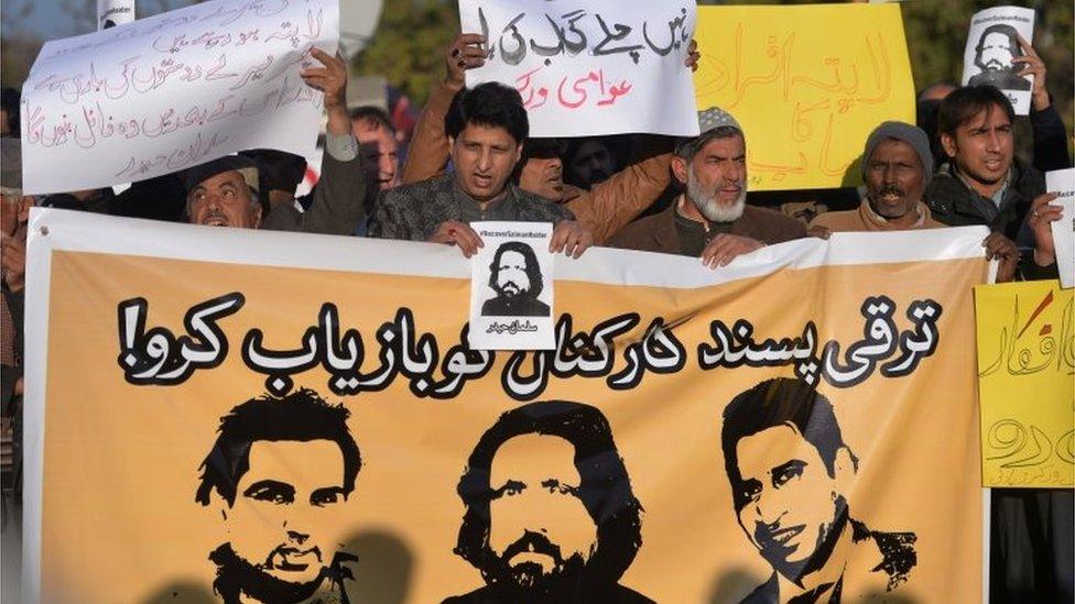 Pakistani human rights activists hold images of bloggers who have gone missing during a protest in Islamabad on January 10, 2017.