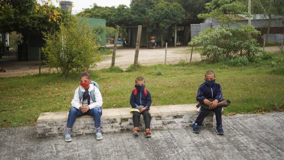 Siblings and students Alicia Camacho, Sergio Camacho, and David Camacho, wait to go into the classroom at Escuela 30, a rural school that has resumed classes after a month off due to the coronavirus disease (COVID-19), in San Jose, Uruguay April 22, 2020.