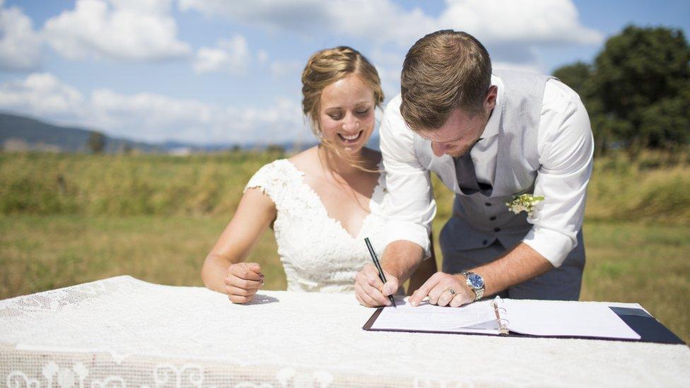 A couple signing a marriage register