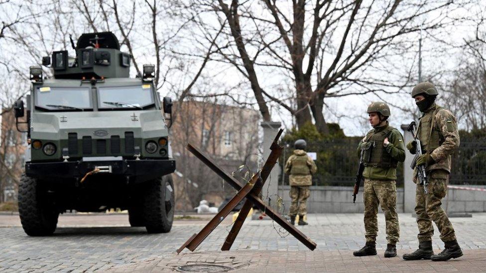 Ukrainian military forces block a road in Kyiv