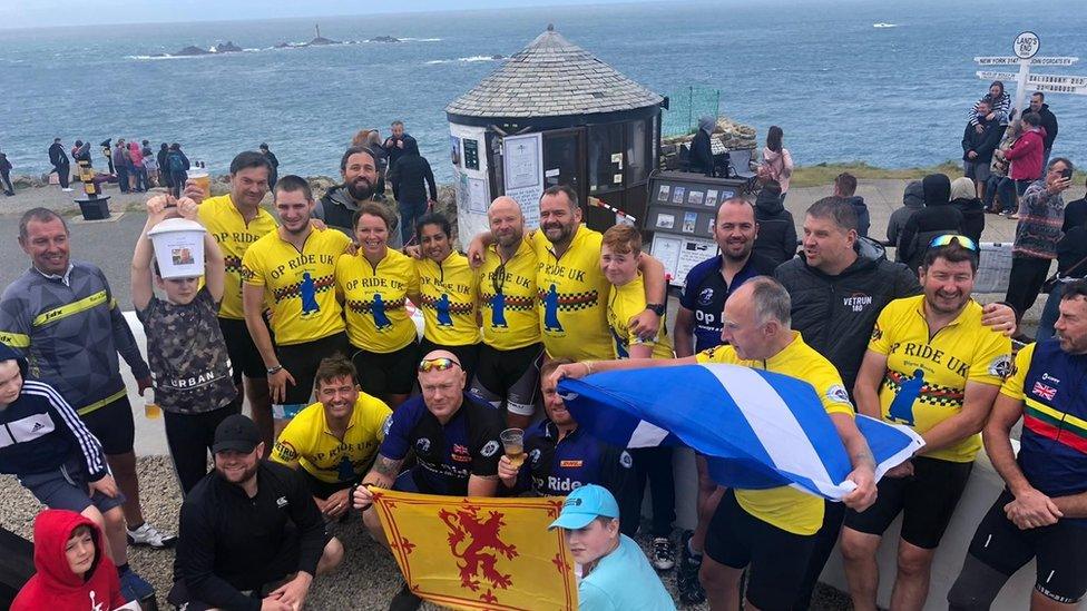 Veterans holding flags and celebrating at Land's end