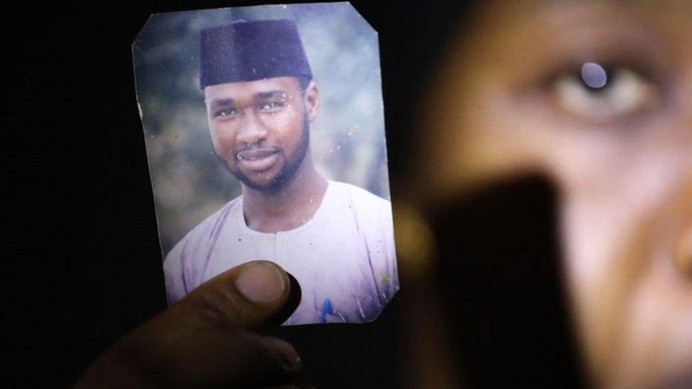 Amina Ahmed, wife of Mubarak Bala, an outspoken atheist who was charged with blasphemy, displays her husband's photo at their home in Abuja, Nigeria, on March 11, 2021.