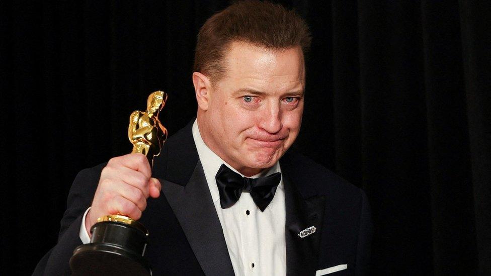 Brendan Fraser holding his Oscar up