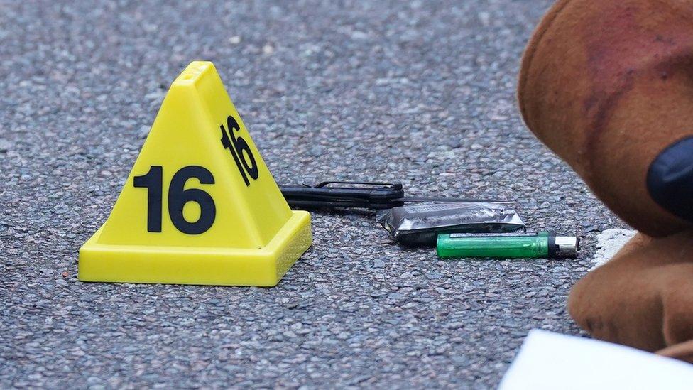 A knife on the floor next to a lighter and a marker