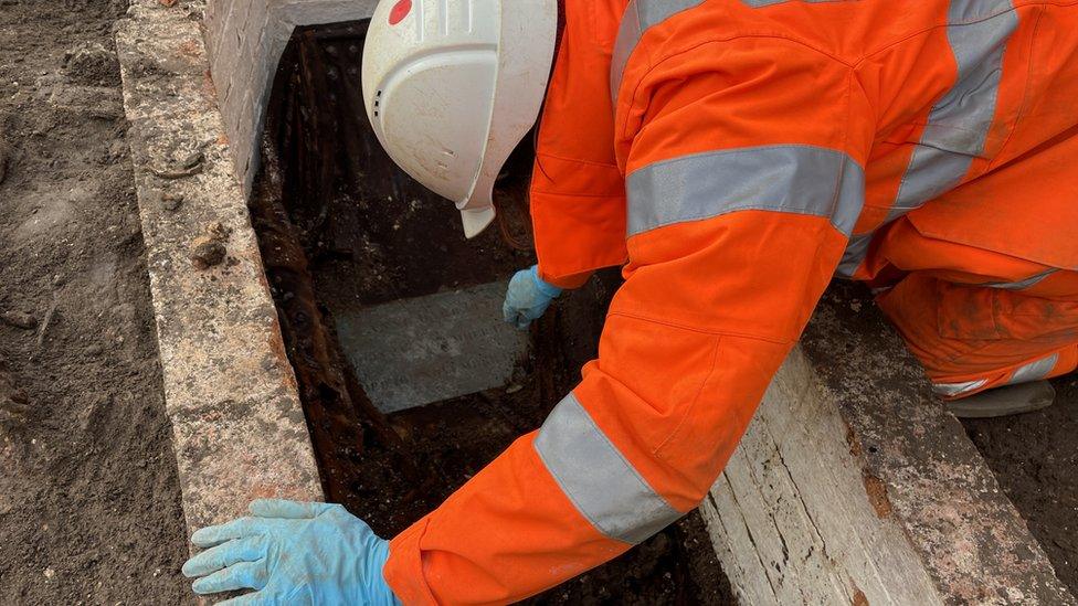 A brick-lined grave being excavated