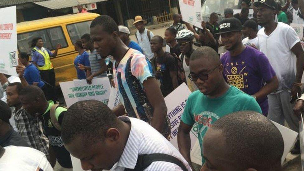 Demonstrators marching and carrying placards