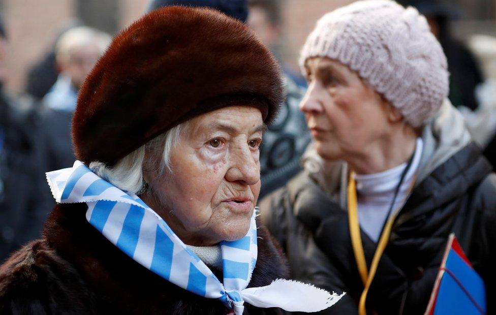 Holocaust survivors walk through the grounds of former German Nazi death camp Auschwitz