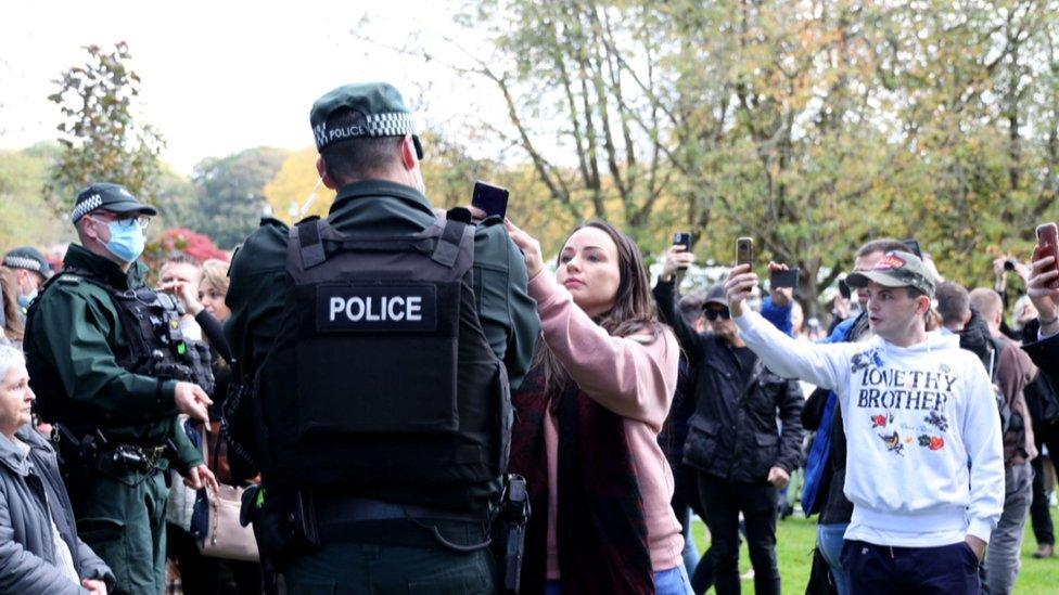 police officer with phone cameras pointed at him