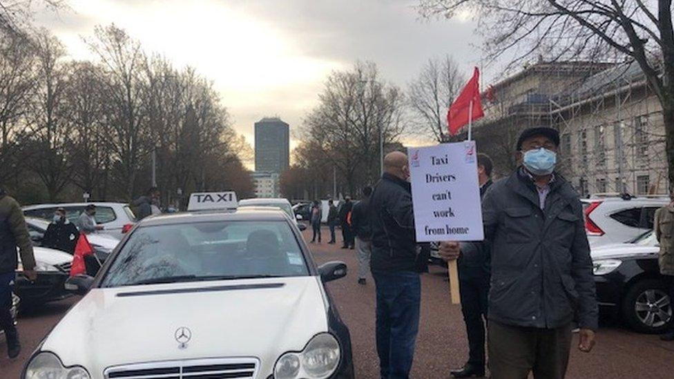 Drivers hold signs and protest outside city hall