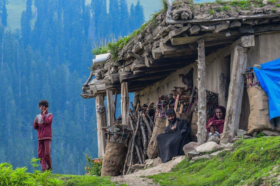 A shepherd family sitting outside their mud house at Tosa Maidan