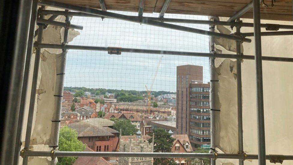 One of the holes cut into the plastic covering St Francis Tower, Ipswich