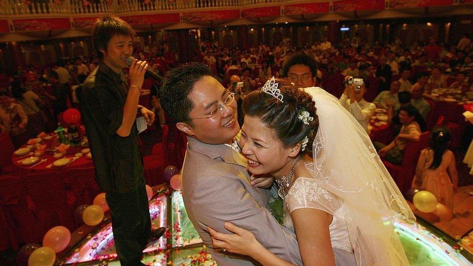 A couple hug during feast at a wedding ceremony on 6 May 2006 in Nanchang of Jiangxi Province, China.