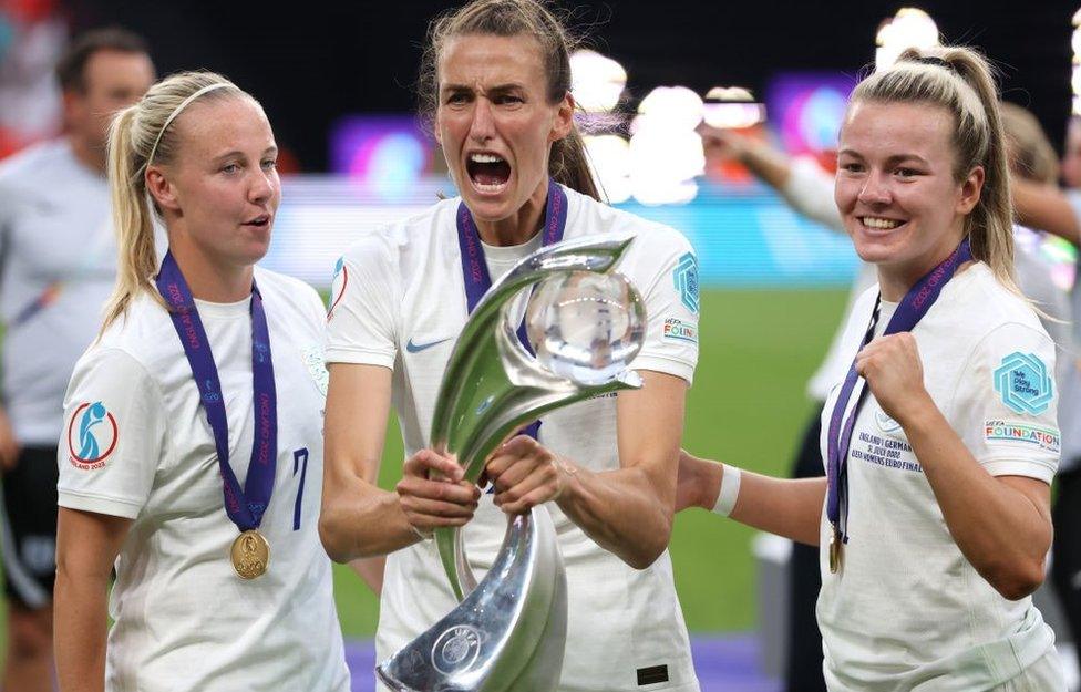 Jill Scott celebrates with the trophy along with team mates Beth Mead and Lauren Hemp