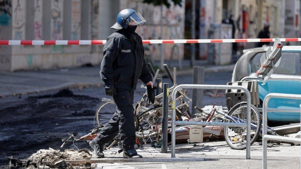 A police officer walks past extinguished barricades