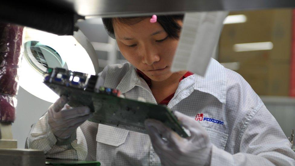 A worker inspects a motherboard on a factory line at the Foxconn plant in Shenzen on May 26, 2010