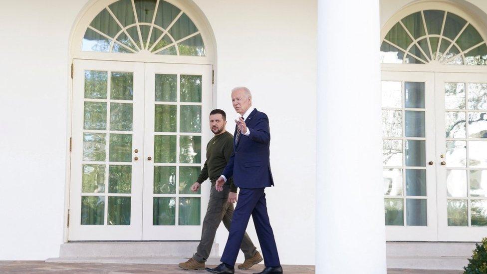 Joe Biden and Volodymyr Zelensky walk to the Oval Office