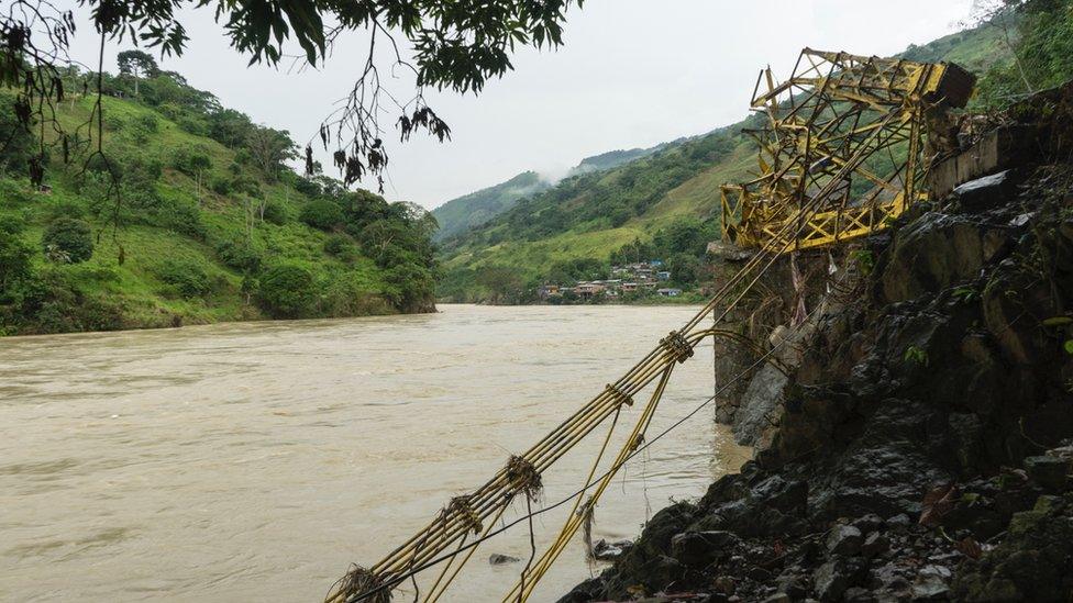 Twisted metal lies by the bank of the river Cauca