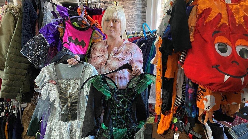 Jen Wake at Uniform for all Northumberland, holding two girls' Halloween costumes