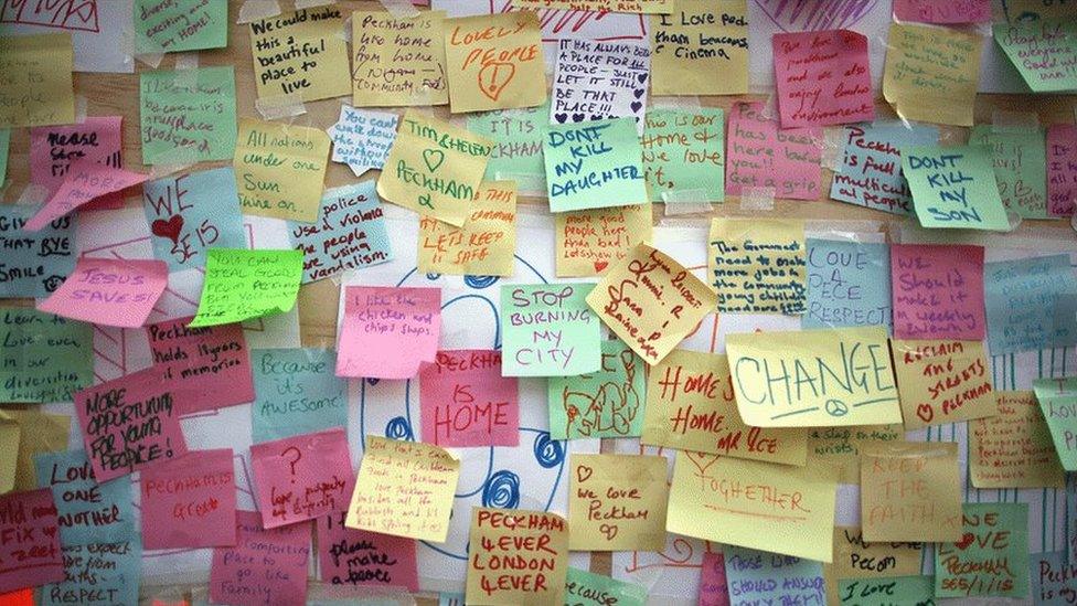 Notes stuck on a riot hit building share messages of peace and love