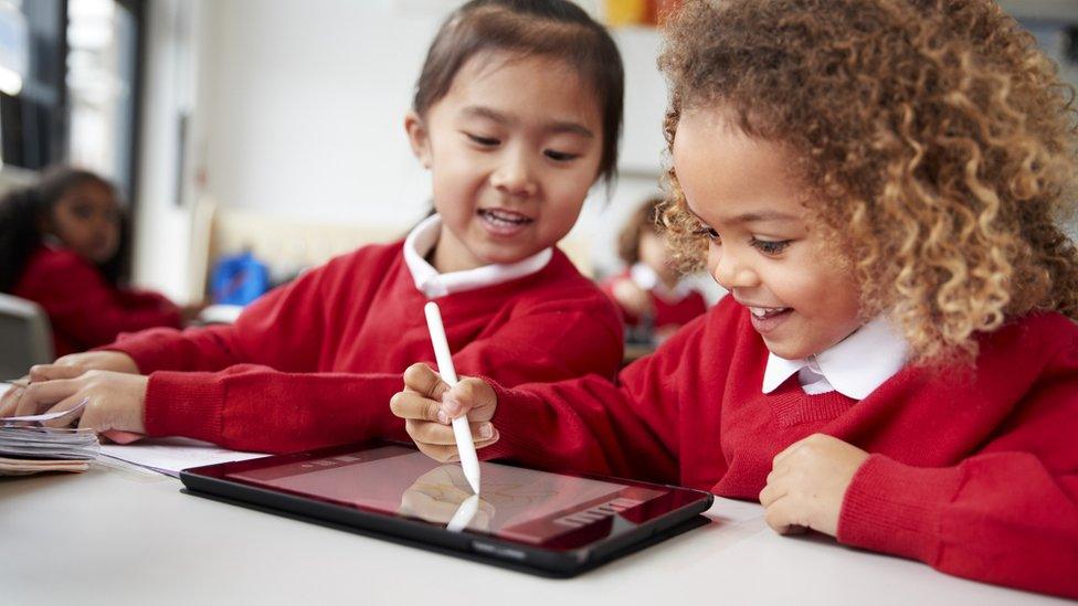 two girls working together on ipad