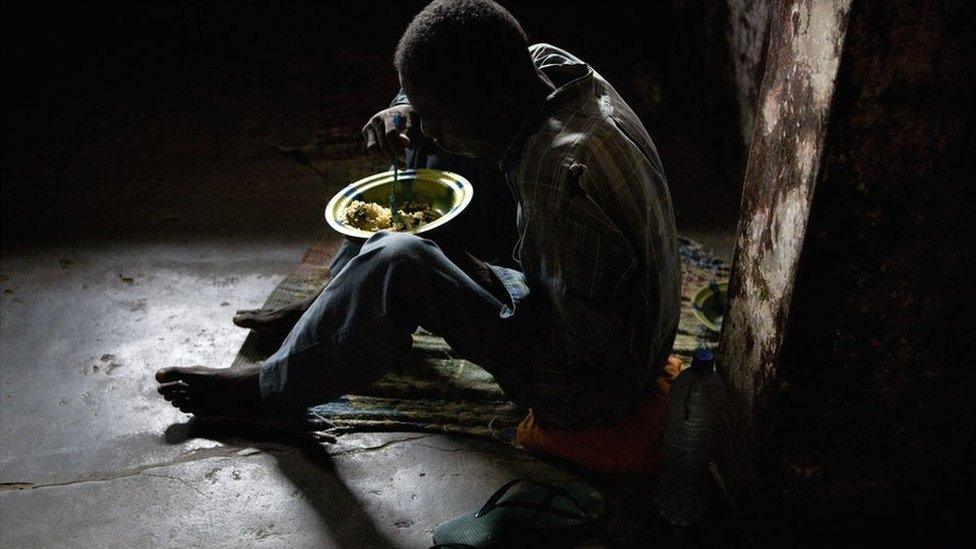 A prisoner at Liberia's Monrovia Central Prison eats a bowl of rice - 2011