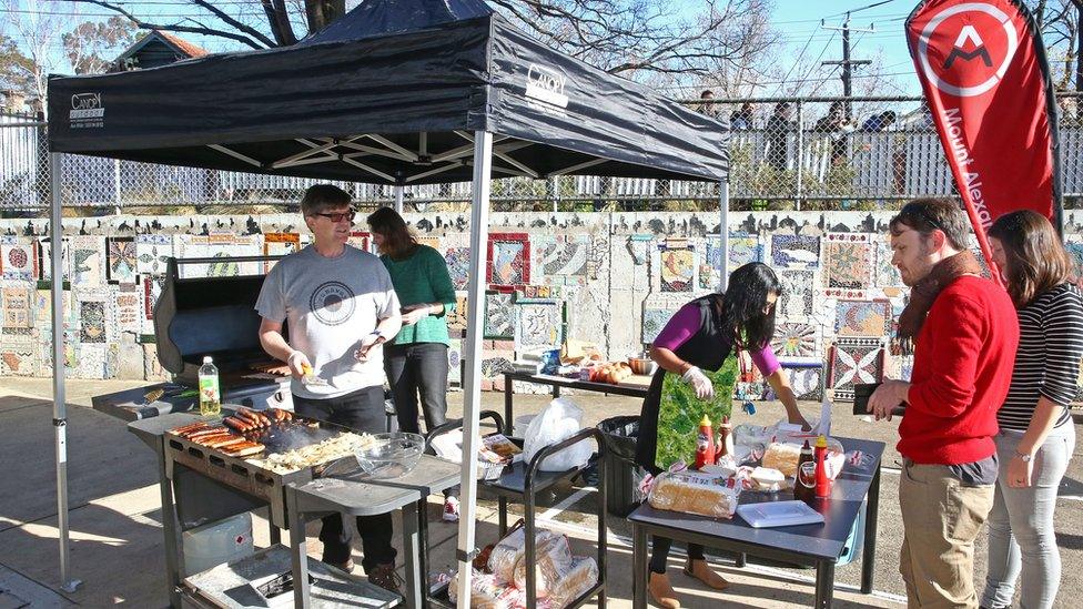 Volunteers cook sausages at a "sausage sizzle" as people vote in the national election at a polling station in Melbourne, Australia.