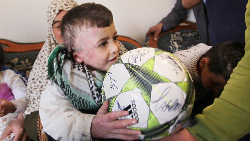 Ahmed Dawabsha holds a football while visiting his relatives in 2016