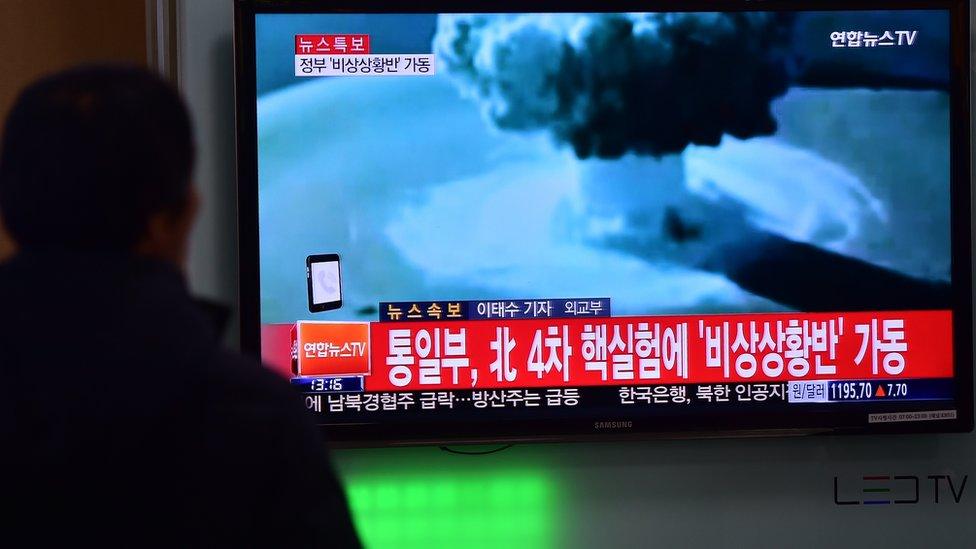 People watch a news report on North Korea's first hydrogen bomb test