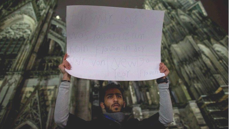 A man hold a placard reading "Sorry for what happened with the woman in Cologne in New Year"s Eve, 90 women" outside the main station in Cologne, Germany, 06 January 2016.