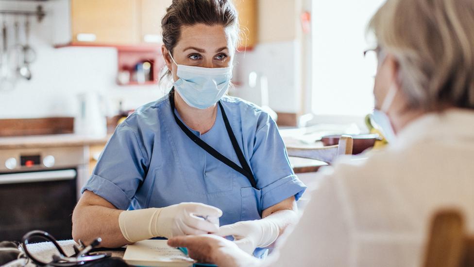 Stock image of a nurse with a patient at home