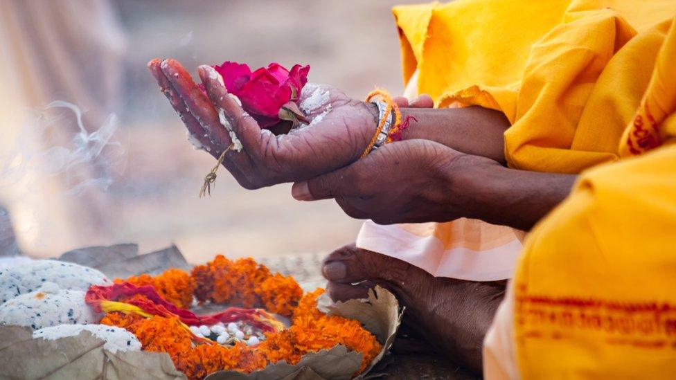 Sacred flowers are taken for worship on hand at river Ganges