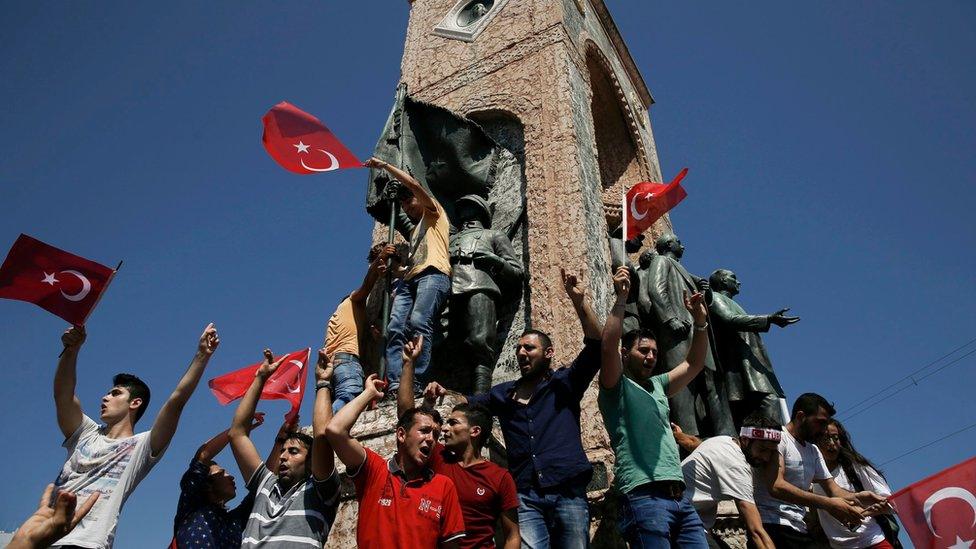 People gathered on a monument in Taksim Square