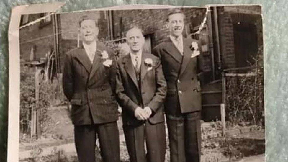 Black and white photo of three men in wedding suits