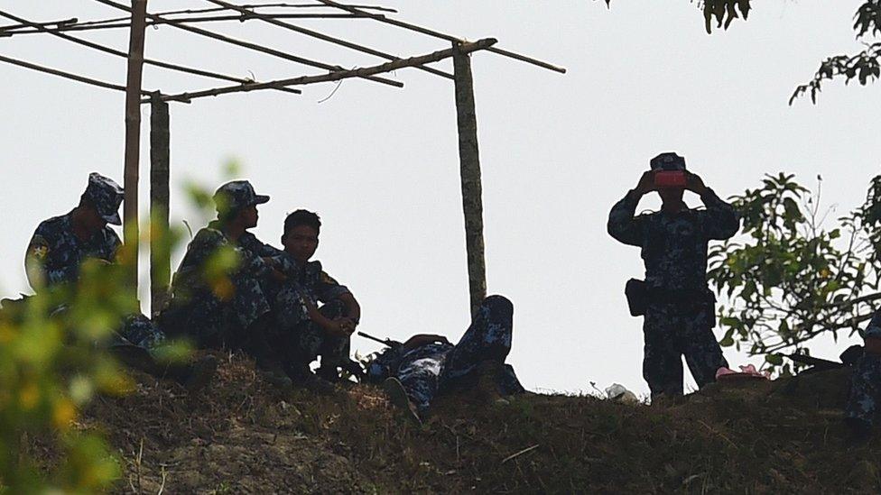 Myanmar security forces keep watch over the camp