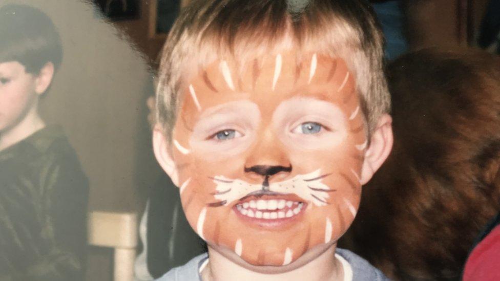 Conner Marshall as a child with his face painted like a tiger