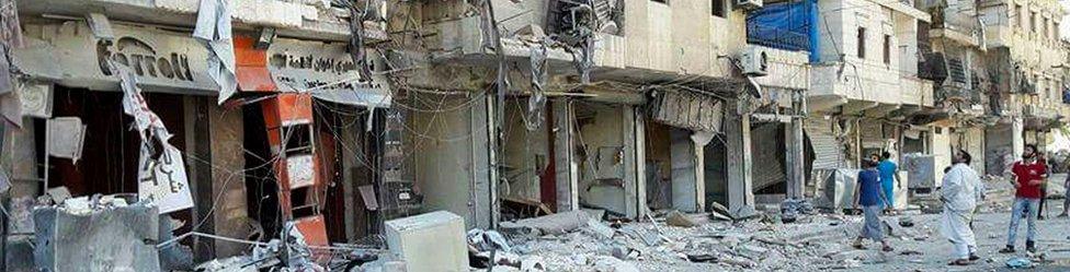 In this photo provided by the Syrian Civil Defence White Helmets, men stand in rubble after airstrikes hit eastern Aleppo, Syria, Friday, 9 September 2016.