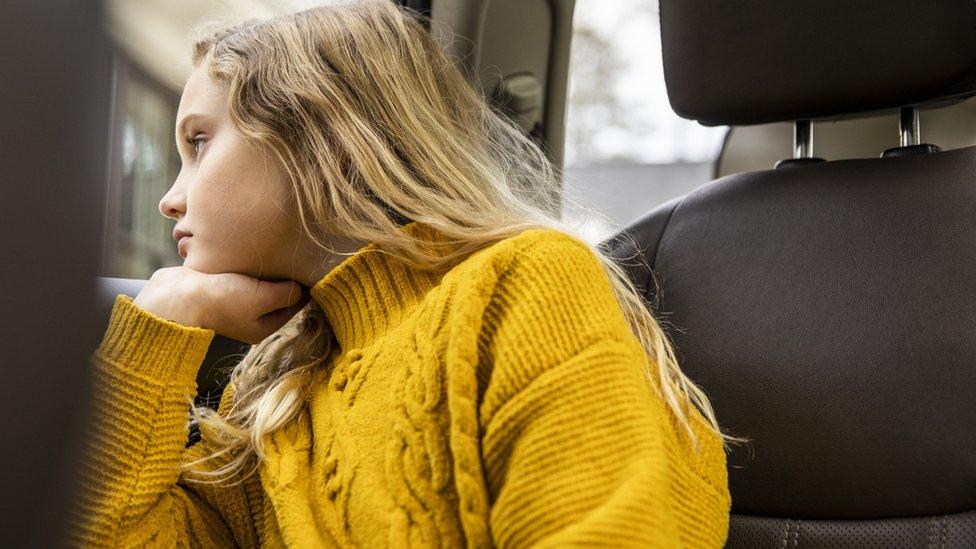 A girl looking bored in a car