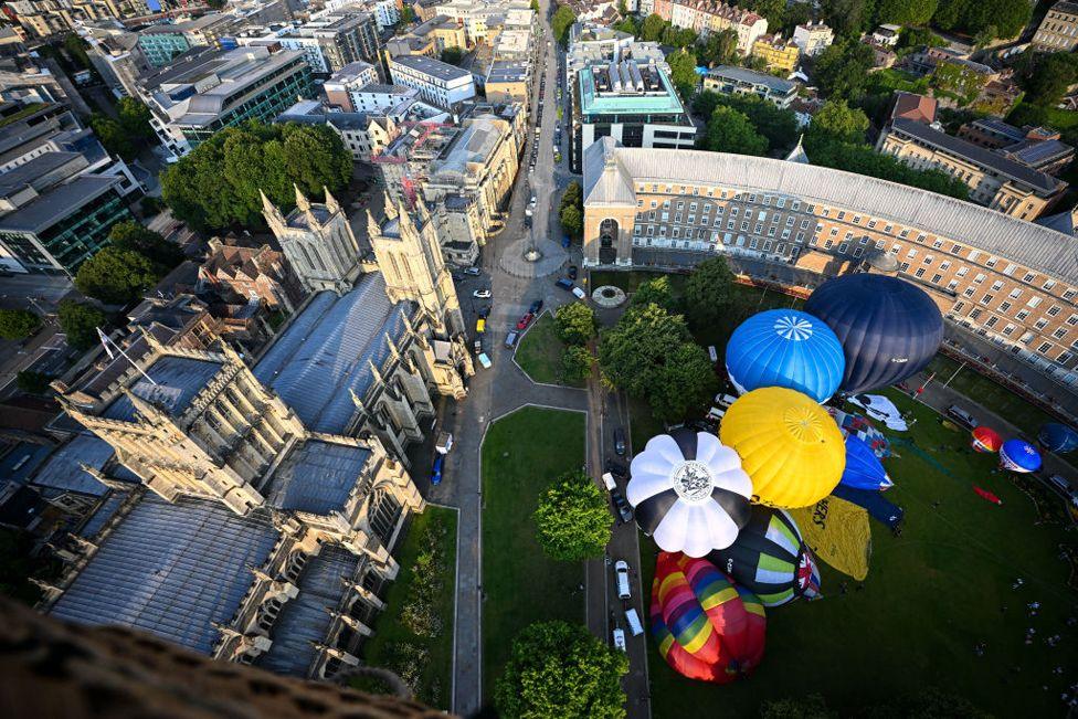 A fleet of hot air balloons take off from College Green and Queen Square to mark the countdown to the 46th Bristol International Balloon Fiesta on July 24, 2024 in Bristol, England