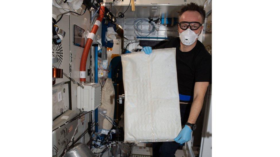 European Space Agency astronaut Matthias Maurer changes out the bladder (bag) in the space station's Brine Processor Assembly.