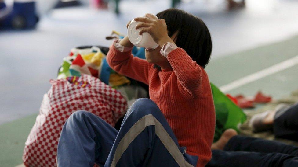 An evacuee girl eats food in a shelter set up at a gymnasium near the industrial park hit by a landslide in Shenzhen, Guangdong province, 22 December 2015