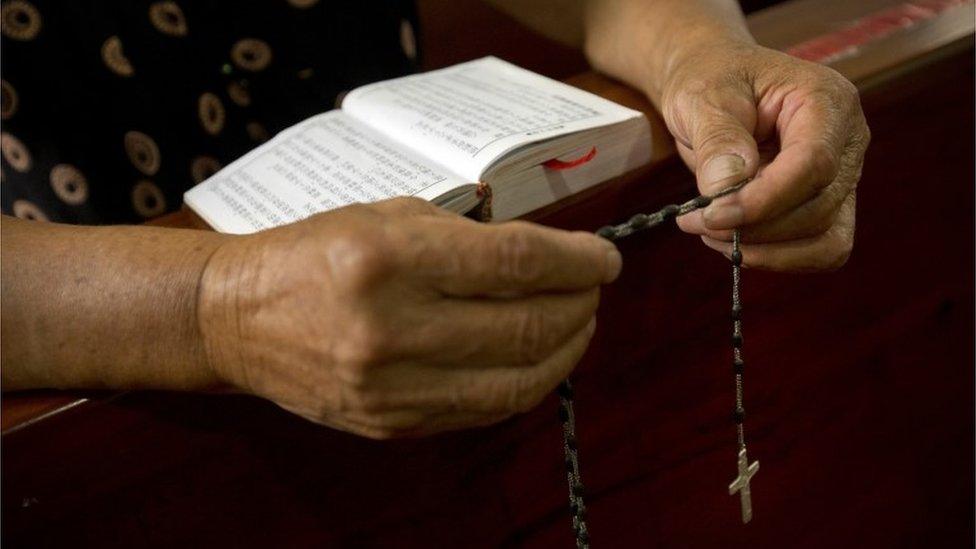 A Christian woman reads a bible at a church in Zhejiang, China (30 July 2015)