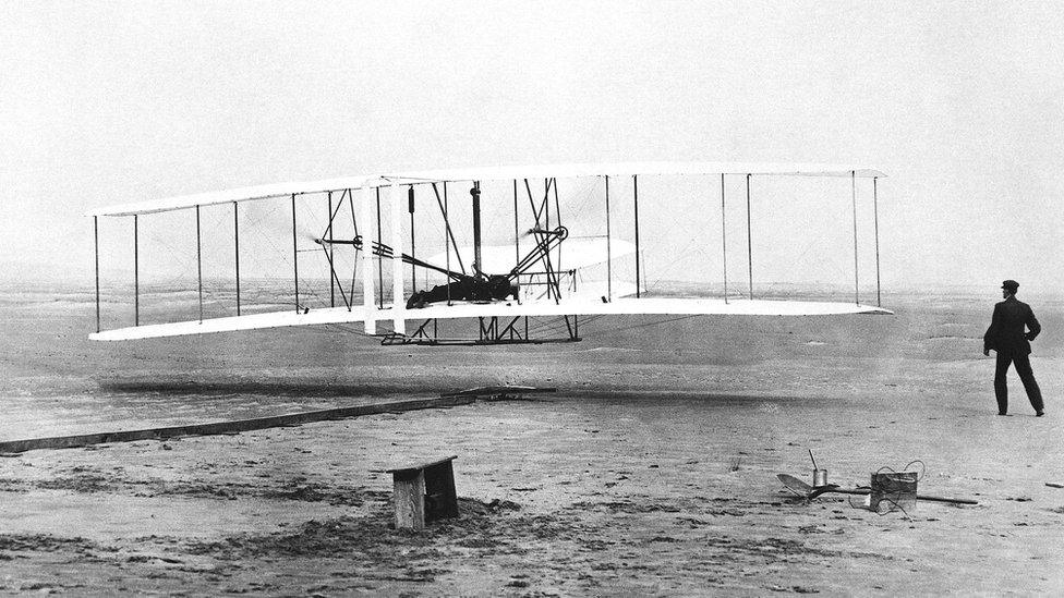 The Wright Flyer as his brother Wilbur Wright looks on when the plane made its s first flight at Kitty Hawk, North Carolina, Dec. 17, 1903.