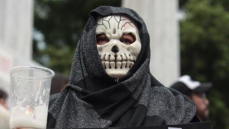 A woman wearing a skull mask takes part in a protest demanding justice in the case of the multiple homicide in which Ruben Espinosa on 8 August 2015