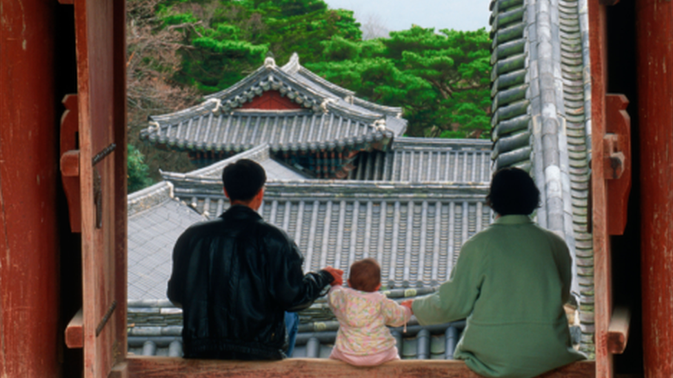 A Korean family viewed from the back at a temple