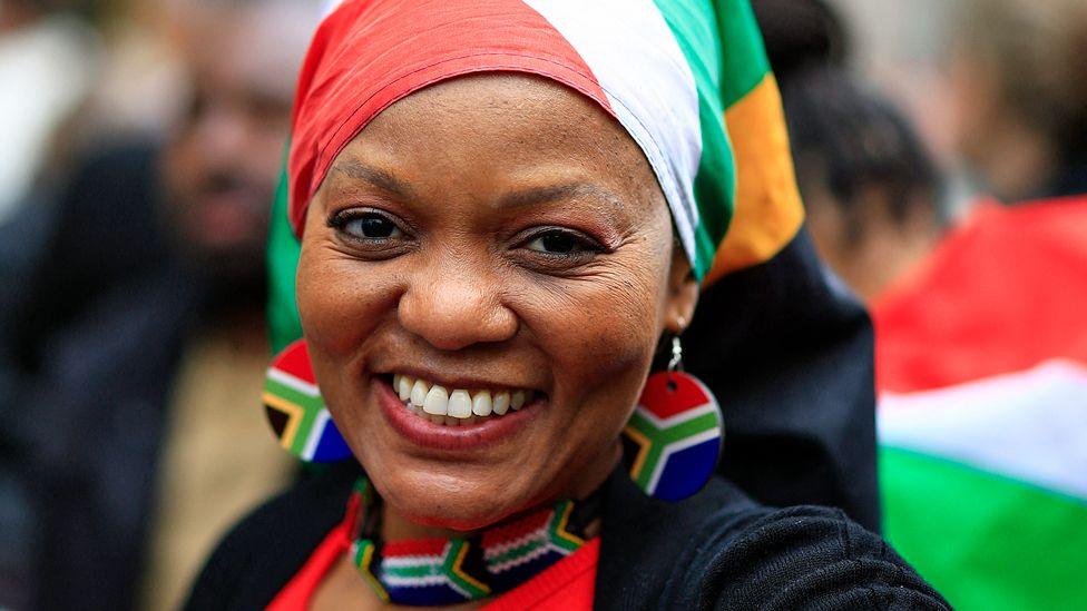 Woman wearing South Africa flag headscarf and earrings